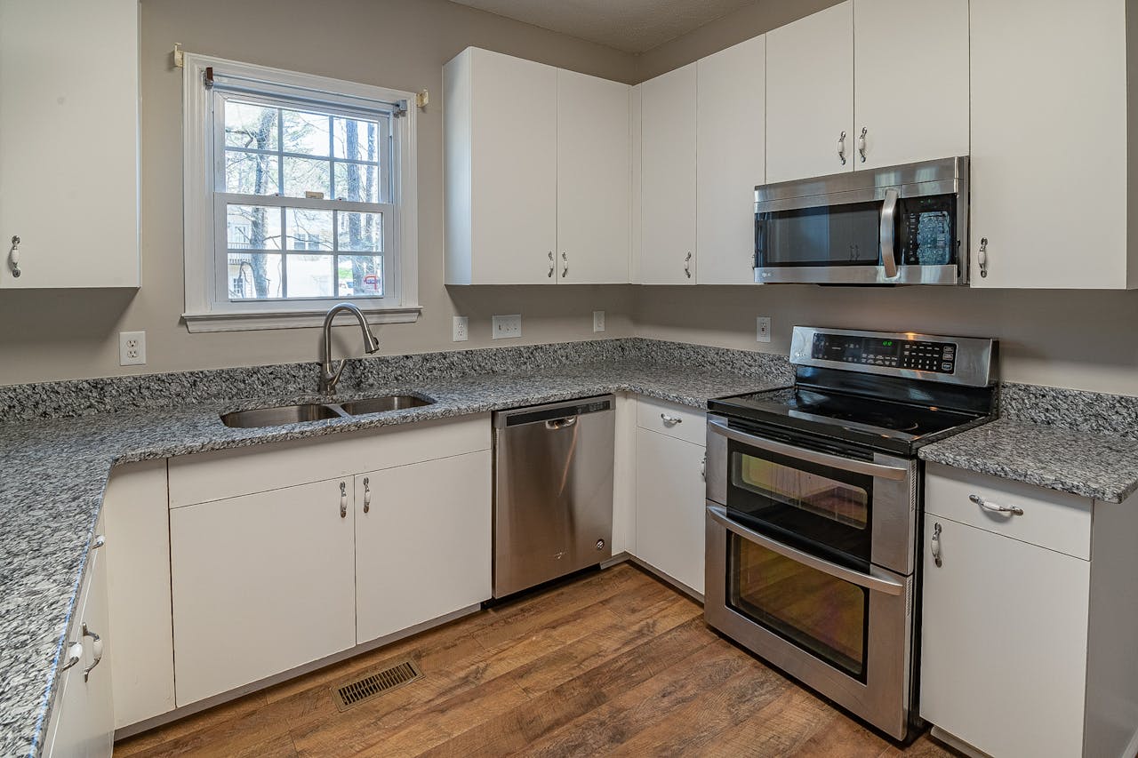 services-02 A sleek modern kitchen featuring stainless steel appliances and granite countertops.
